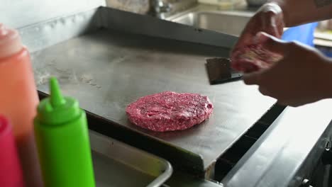 Unrecognizable-chef-cooking-cutlets-for-hamburgers-on-hot-surface