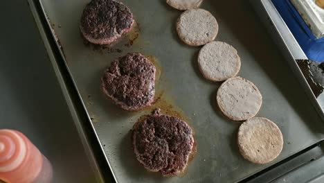 Grilling-hamburger-buns-and-cooking-cutlets-in-kitchen