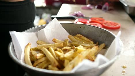 Crop-cook-seasoning-French-fries-in-kitchen