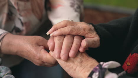 Crop-senior-women-holding-hands