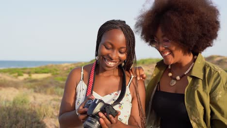 Happy-black-girlfriends-with-photo-camera-in-summer-nature