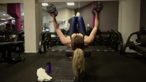 Woman-lifting-dumbbells-on-bench