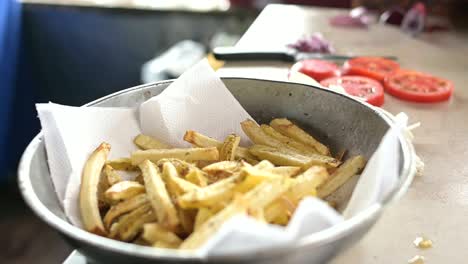 Crop-cook-seasoning-French-fries-in-kitchen