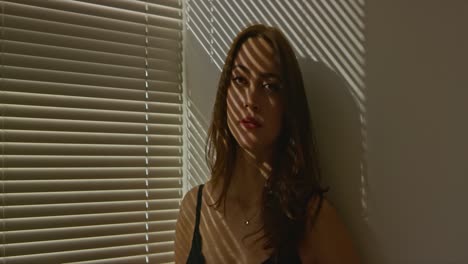 Woman-posing-in-shadows-of-blinds