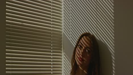 Woman-peeking-out-through-blinds