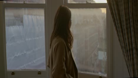 Woman-opening-window-in-apartment-in-the-morning