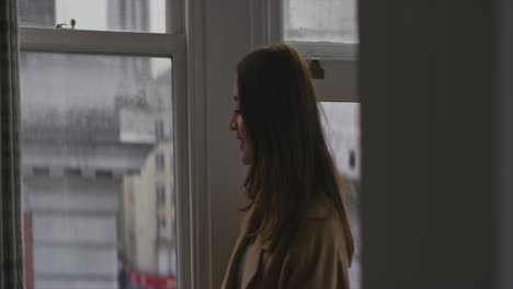 Woman-opening-window-in-apartment-in-the-morning