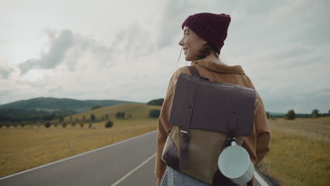 Female-tourist-with-backpack-walking-on-road