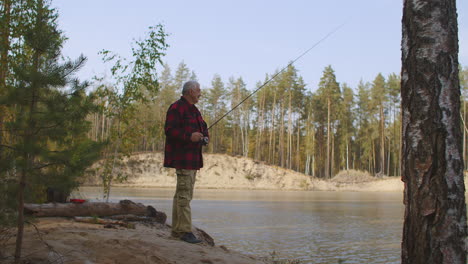 middle-aged-man-is-relaxing-in-forest-fishing-on-coast-of-river-at-weekend-male-entertainment-at-nature