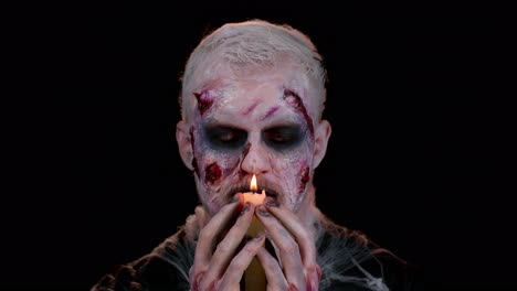 Erschreckender-Mann-Mit-Blutigen-Halloween-Zombie-Make-up-Zaubersprüchen-über-Kerze,-Voodoo-Rituale
