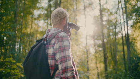 Male-Hiker-With-Backpack-And-Binocular-In-Forest