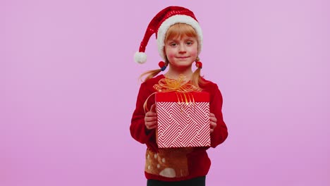 Una-Niña-Pequeña-Adolescente-Graciosa-Viste-Un-Suéter-Rojo-De-Navidad-Presentando-Una-Caja-De-Regalo-De-Navidad,-Venta-De-Compras