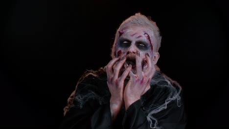 Zombie-Mann-Mit-Make-up,-Wunden,-Narben-Und-Weißen-Kontaktlinsen,-Der-Unter-Krämpfen-In-Die-Kamera-Blickt
