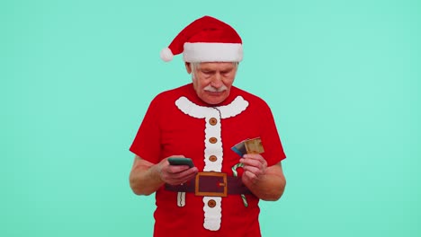Senior-Christmas-grandfather-man-use-mobile-cell-phone-plastic-credit-bank-cards,-win-calebrate,-wow