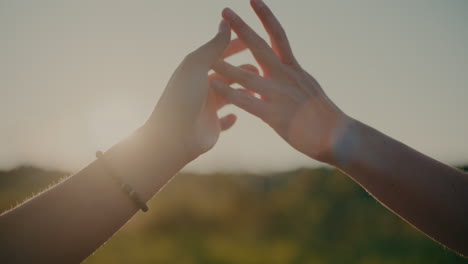 Female-Friends-Touching-Hands-Against-Sky