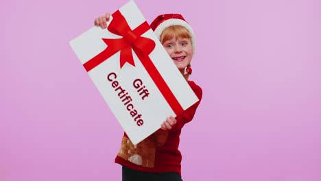 Lustiges-Mädchen-Trägt-Weihnachtsmütze-Und-Weihnachtsmütze-Und-Präsentiert-Karte,-Geschenkgutschein,-Gutschein,-Gewinnergutschein