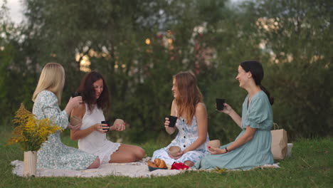 Junge-Frauen-Diskutieren-Nach-Dem-Modellieren-Aus-Ton-über-Die-Resultierenden-Produkte,-Trinken-Tee,-Kaffee,-Getränke,-Lachen,-Kommunizieren-In-Der-Natur-Unter-Freiem-Himmel.-Kreative-Aktivität-Hobbys-Picknick.