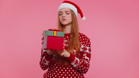 Happy-girl-wears-red-Christmas-holiday-sweater-received-present,-interested-in-what-inside-gift-box