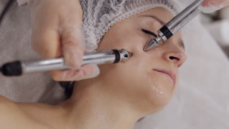 Kosmetologe-Arzt-Lässt-Frau-Mikroströme-Gesichtstherapie-Mit-Elektrischen-Impulsen-Im-Spa-Salon
