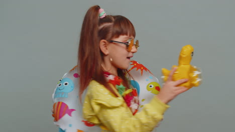 Traveler-tourist-child-girl-kid-celebrating-vacation-win,-dancing-with-swimming-inflatable-duck-toy