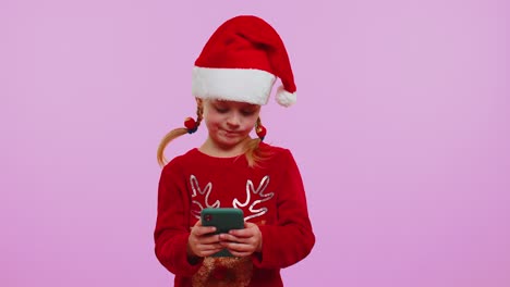 Girl-in-Christmas-sweater,-hat-using-mobile-phone-typing-new-post-on-web,-shopping-online,-browsing