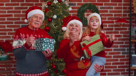 Glückliches-älteres-Großelternpaar-Mit-Enkelin,-Die-Brennende-Bengalische-Weihnachtslichter-In-Der-Hand-Hält