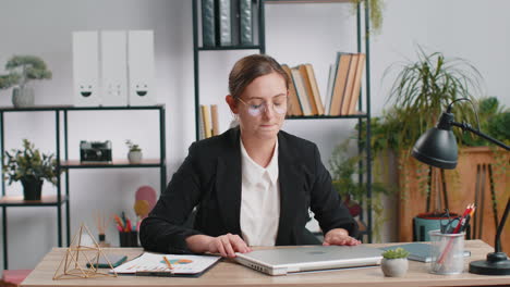 Mujer-De-Negocios-Trabajando-En-Una-Computadora-Portátil-Meditando-Haciendo-Ejercicios-De-Respiración-De-Yoga-En-Posición-De-Loto-En-La-Oficina