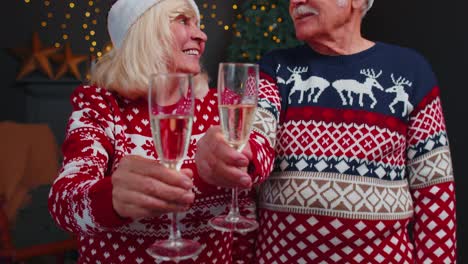 Fröhliches-älteres-Familienpaar-Feiert-Weihnachten-Zu-Hause,-Klirrt-Mit-Gläsern-Und-Trinkt-Champagner