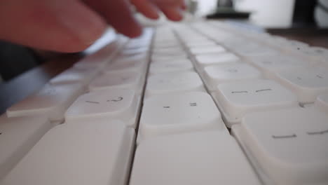 Close-up-typing-on-computer-keyboard-with-hands-and-fingers.-Macro-dolly-shot.-Computer-programming-text-chat-online-messaging-and-online-marketing-business-concept.
