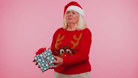 Abuela-Mujer-En-Suéter-Santa-Navidad-Recibiendo-Caja-De-Regalo-Expresando-Asombro-Felicidad
