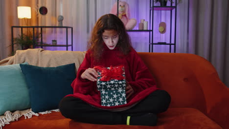 Preteen-girl-opening-gift-box-with-light-glow-inside-amazed-satisfied-with-present-birthday-surprise