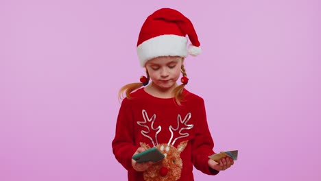 Mädchen-Im-Weihnachtspullover-Benutzt-Smartphone-Mit-Kreditkarte,-Während-Sie-Geld-Beim-Online-Einkauf-überweist