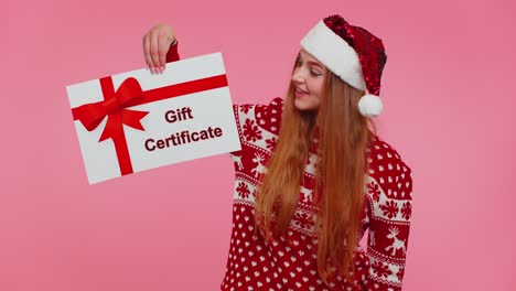 Adult-girl-wears-red-New-Year-sweater-and-hat-presenting-card-gift-certificate-coupon-winner-voucher