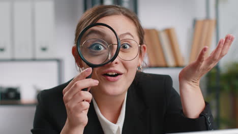 Business-woman-holding-magnifying-glass-near-face,-looking-with-big-zoomed-eye,-searching,-analysing