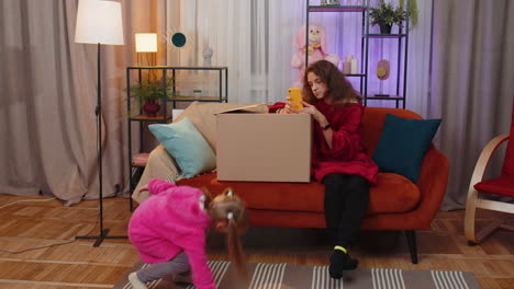 Little-children-girls-siblings-playing-hide-and-seek,-peekaboo-game,-hiding-inside-cardboard-box