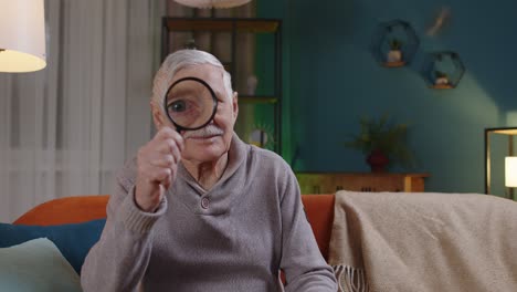 Anciano-Abuelo-Mirando-A-Través-De-Lupa,-Leyendo,-Investigando,-Analizando-En-Casa