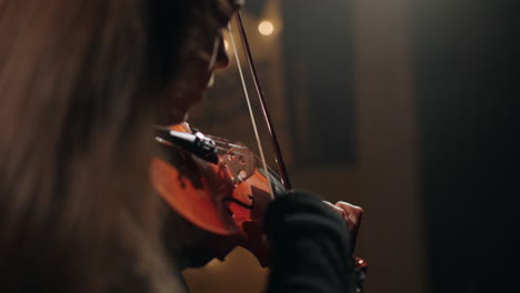 woman-violinist-in-black-clothes-is-playing-classic-music-in-dark-philharmonic-hall