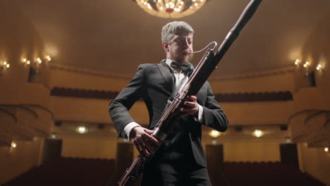 talented-bassoonist-with-bassoon-on-scene-of-old-opera-house-or-music-hall-portrait-of-musician
