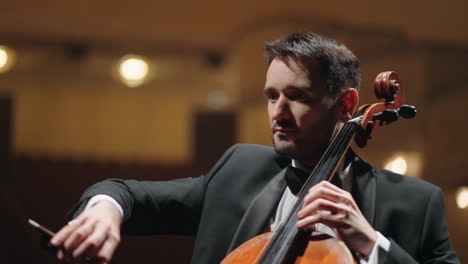 male-musician-is-playing-cello-in-philharmonic-hall-concert-of-classical-music-portrait-of-man-with-violoncello