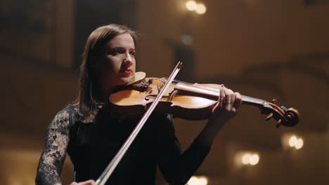 Músico-Femenino-Está-Tocando-El-Violín-En-La-Escena-Del-Music-Hall-Retrato-De-Mujer-Violinista-En-La-Sala-Filarmónica