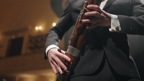 musician-with-bassoon-on-scene-of-opera-house-or-philharmonic-hall-closeup-of-hands