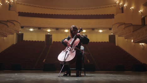lonely-woman-is-playing-violoncello-in-empty-music-hall-of-opera-house-female-cellist-is-rehearsing