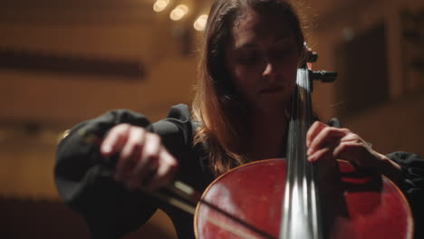 talented-woman-is-playing-violoncello-in-music-hall-female-cellist-is-rehearsing-on-scene-of-music-hall
