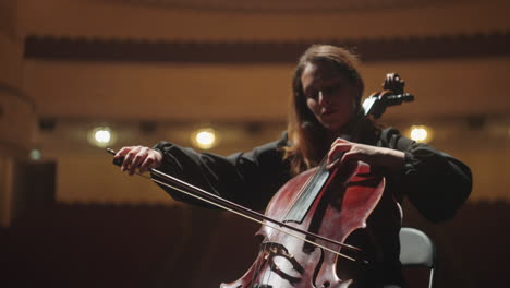 beautiful-woman-is-playing-cello-in-music-hall-female-violoncellist-on-scene-of-opera-house
