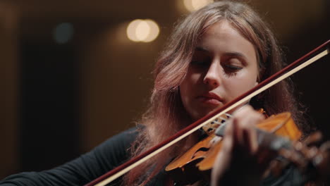 pretty-young-woman-is-playing-fiddle-in-symphonic-orchestra-on-scene-of-music-hall-portrait