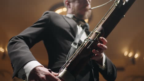 bassoonist-with-instrument-on-scene-musician-is-performing-music-by-bassoon-symphonic-orchestra