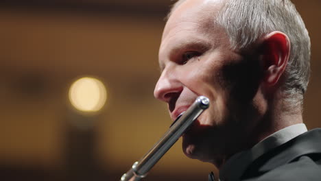 Älterer-Musiker-Spielt-Flöte,-Nahaufnahme-Eines-Männlichen-Gesichts-Und-Eines-Blasinstrumentenflötisten-Im-Konzert