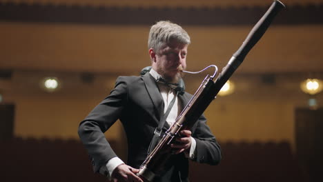 talented-musician-is-playing-bassoon-in-scene-of-music-hall-in-evening-rehearsal-of-symphonic-orchestra