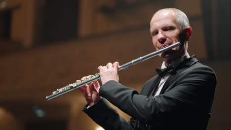 man-is-playing-flute-in-music-hall-musician-in-symphonic-orchestra-or-brass-band-classic-music-concert