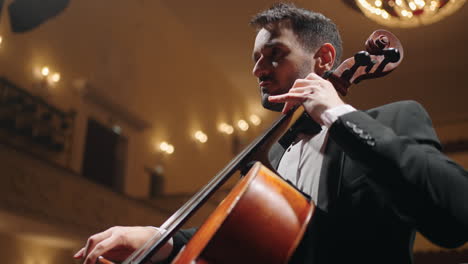 Der-Inspirierte-Cellist-Spielt-Cello-Auf-Der-Bühne-Des-Musiksaalkonzerts-Des-Symphonieorchesters-In-Der-Philharmonie